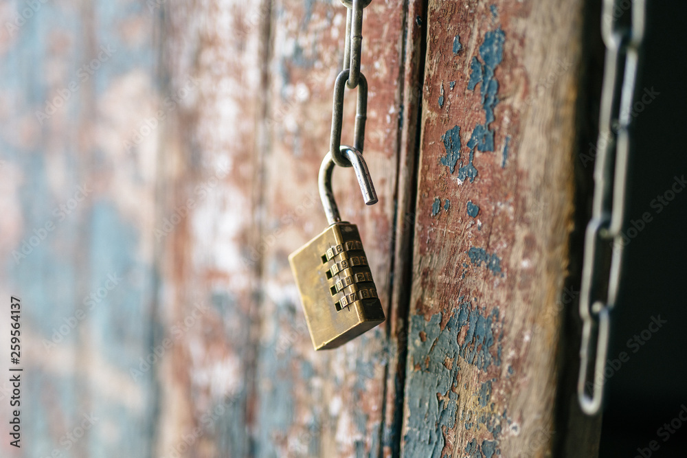 Old padlock on a weathered door that has gone through the ages