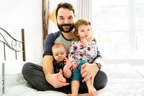 A Nice father with kids on bed