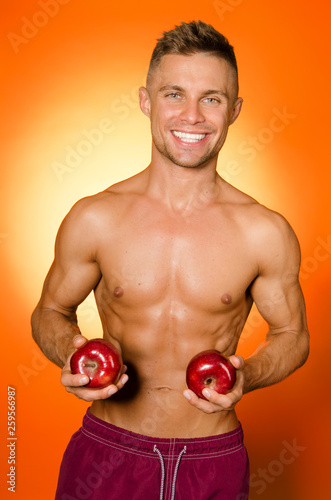 Healthy lifestyle. Sexy guy eats an apple.