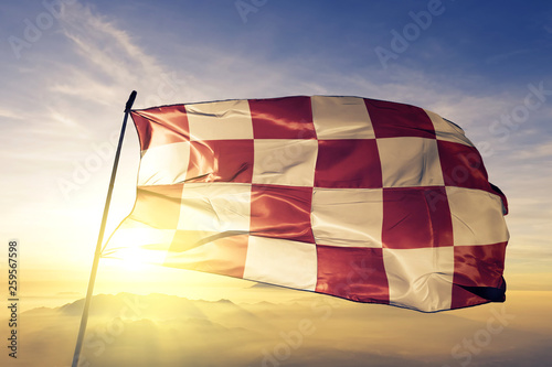 North Brabant province of Netherlands flag waving on the top sunrise mist fog photo
