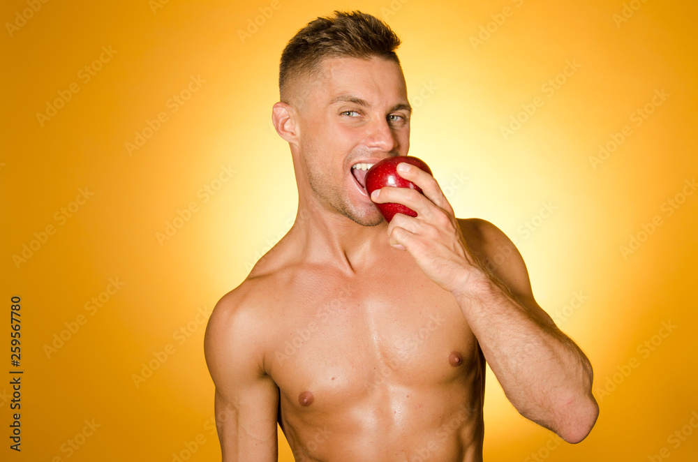 Healthy lifestyle. Sexy guy eats an apple. Stock Photo | Adobe Stock