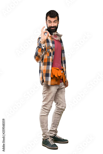 Craftsmen man showing ok sign with fingers over isolated white background