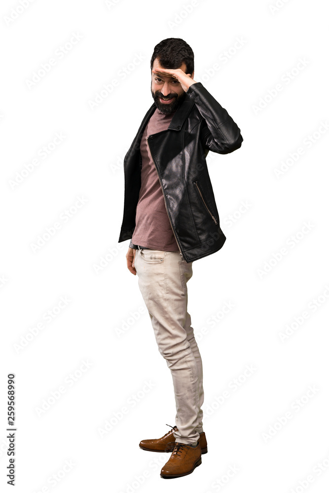 Handsome man with beard looking far away with hand to look something over isolated white background Handsome man with beard looking far away with hand to look something over isolated white background
