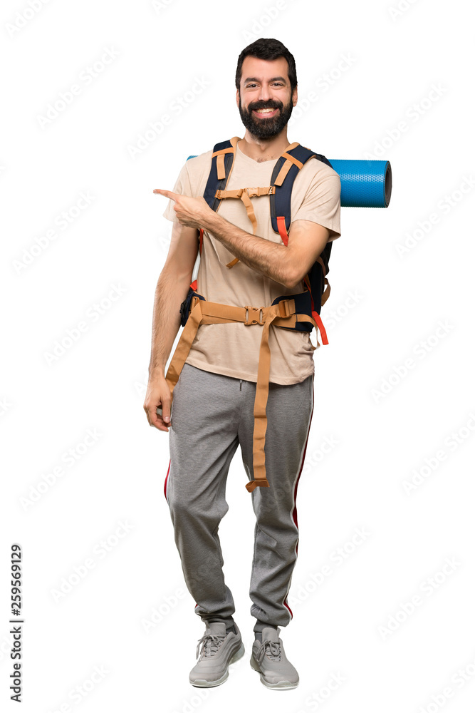 Hiker man pointing finger to the side over isolated white background Hiker man pointing finger to the side over isolated white background