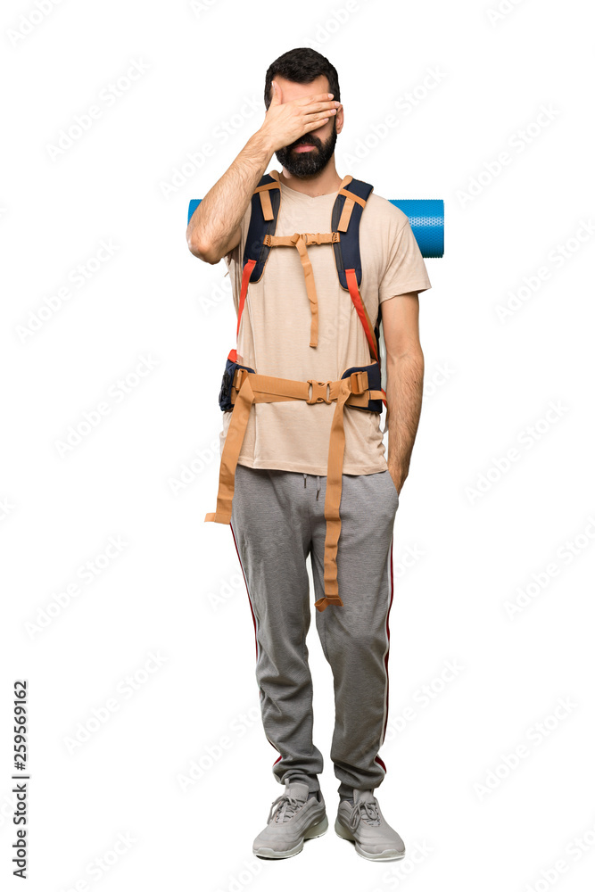 Hiker man covering eyes by hands. Do not want to see something over isolated white background Hiker man covering eyes by hands. Do not want to see something over isolated white background