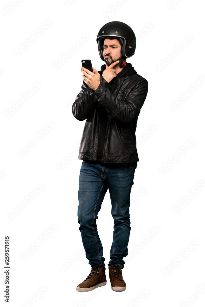 Full-length shot of Biker man thinking and sending a message over isolated white background Full-length shot of Biker man thinking and sending a message over isolated white background