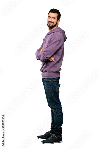 Full-length shot of Handsome man with sweatshirt with arms crossed and looking forward over isolated white background
