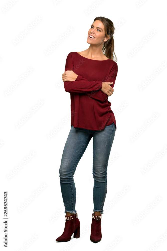 A full-length shot of a Blonde woman looking up while smiling over isolated white background A full-length shot of a Blonde woman looking up while smiling over isolated white background