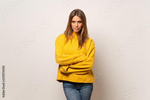Woman with yellow sweater over isolated wall portrait