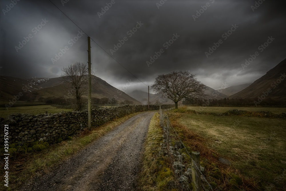 Gravel road with fog against mountains. Lake District National Park Gravel road with fog against mountains. Lake District National Park