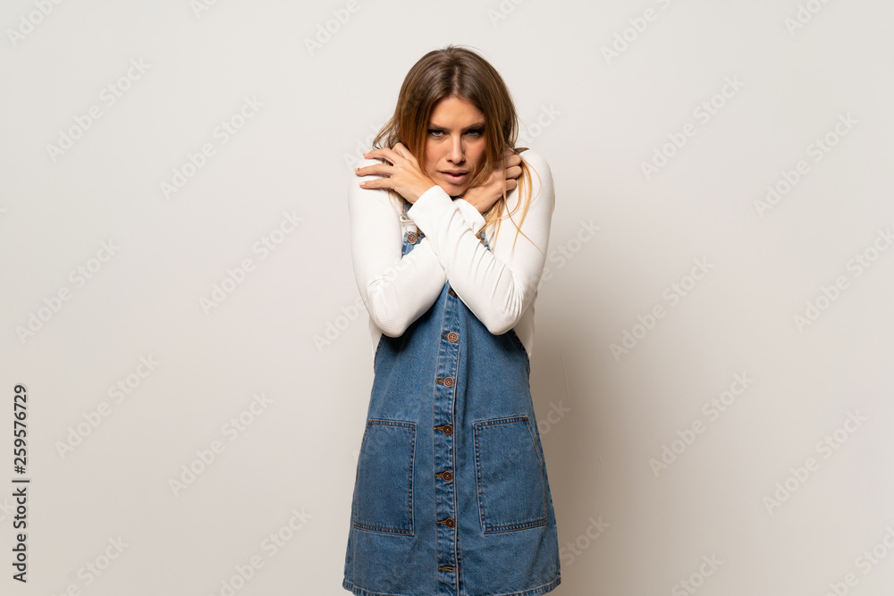 Beautiful woman over isolated white wall freezing Beautiful woman over isolated white wall freezing