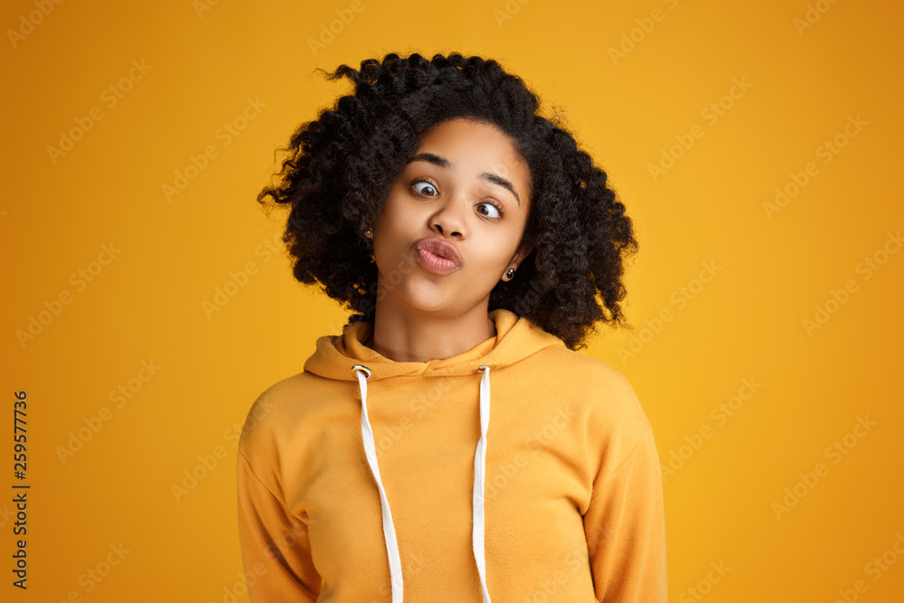 Portrait of crazy african american young woman with beautiful smile dressed in casual clothes over yellow background. Portrait of crazy african american young woman with beautiful smile dressed in casual clothes over yellow background.