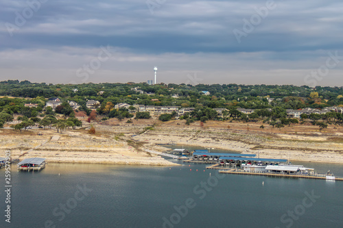 Travis Lake near Austin Texas during a drought with the waterline way down - view from above with marinas and buildings and a water tower on shore under stormy sky photo