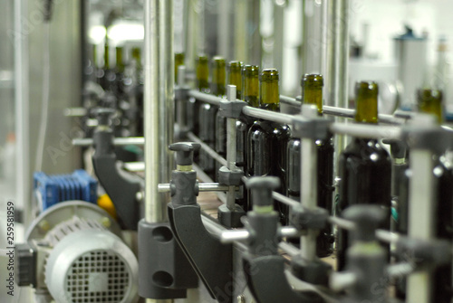 Red wine bottling and sealing conveyor line at winery factory