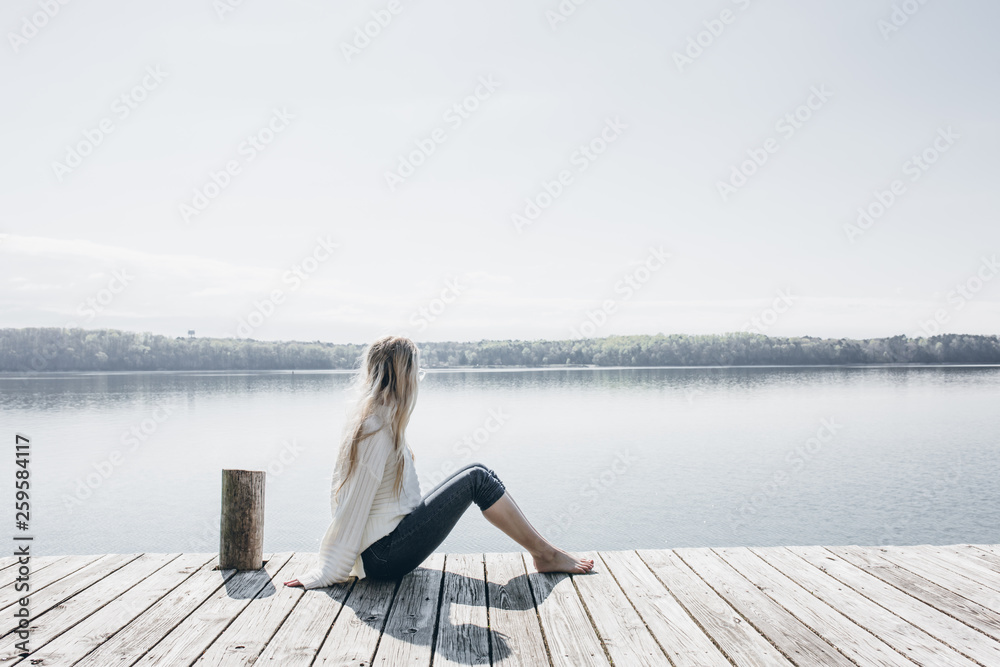Young Woman Sitting on Wooden Dock