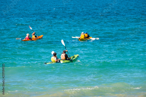 Poeple doing kayaking in the blue ocean.