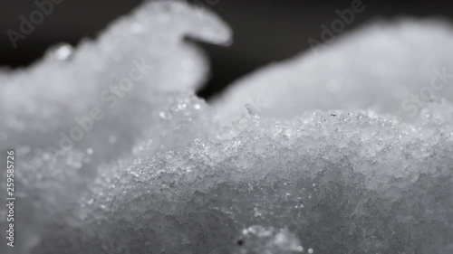 Melting Snow / Melting Ice / Spring Water / Spring Time. Macro time-lapse shot of shiny melting snow particles turning into liquid water. HDR color corrected.