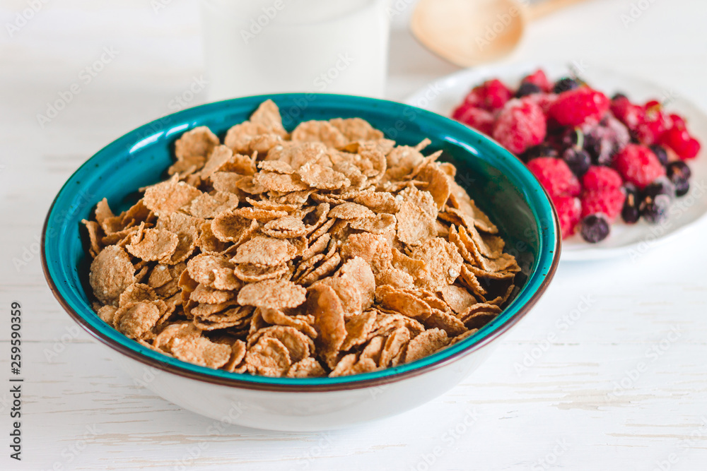 Breakfast cereal with milk on a white background. Flakes on a plate. Muesli with berries and milk Breakfast cereal with milk on a white background. Flakes on a plate. Muesli with berries and milk