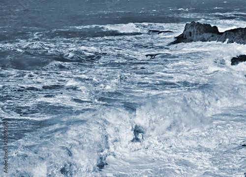 Stormy waves with splashes and foam on the ocean surface during a storm