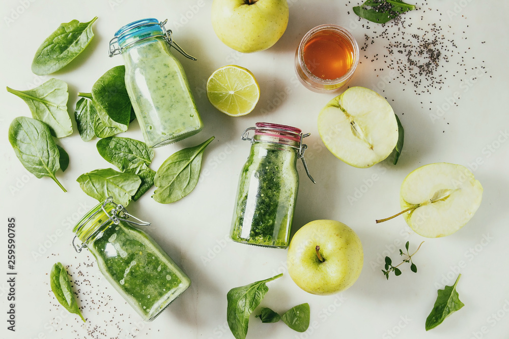 Φωτογραφία Variaty of green spinach kale apple honey smoothies in glass bottles with ingredients above over white marble background