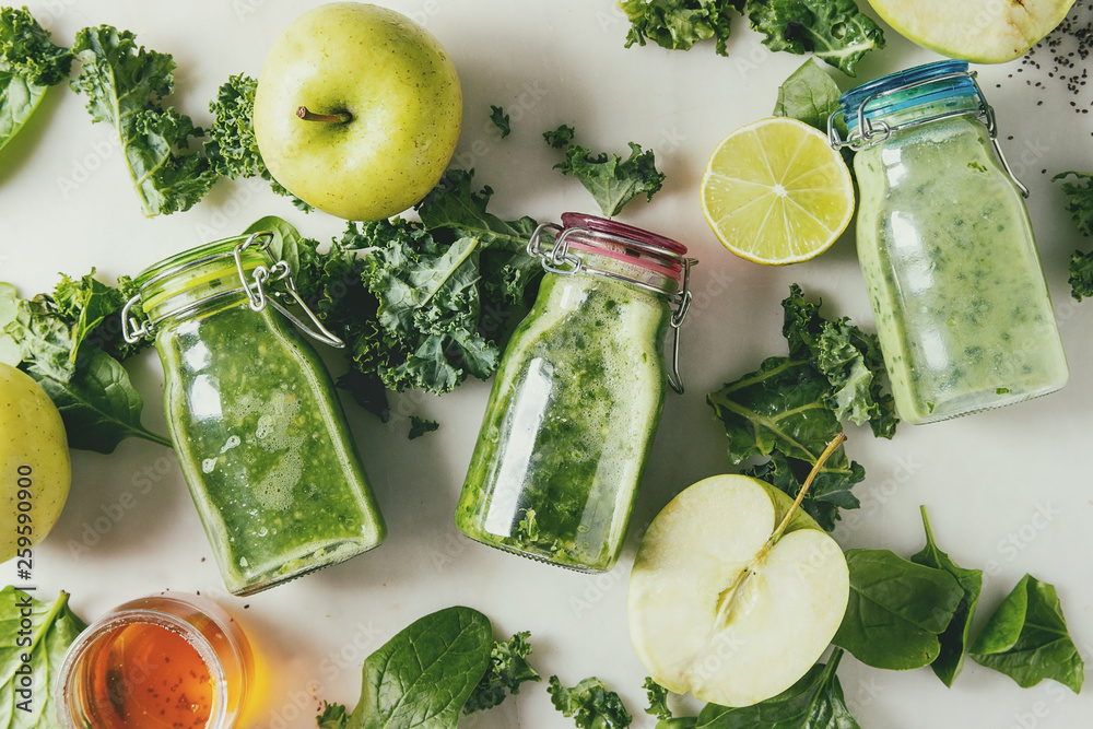 Φωτογραφία Variaty of green spinach kale apple honey smoothies in glass bottles with ingredients above over white marble background