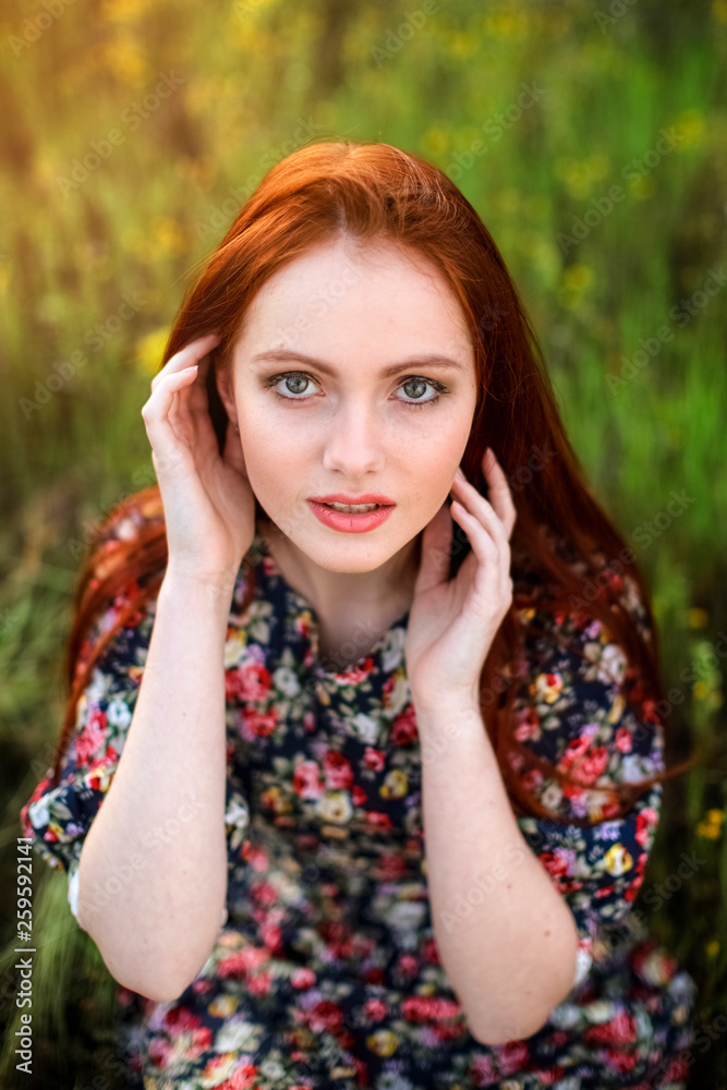 young redhead girl  in the rays of the setting sun, close-up