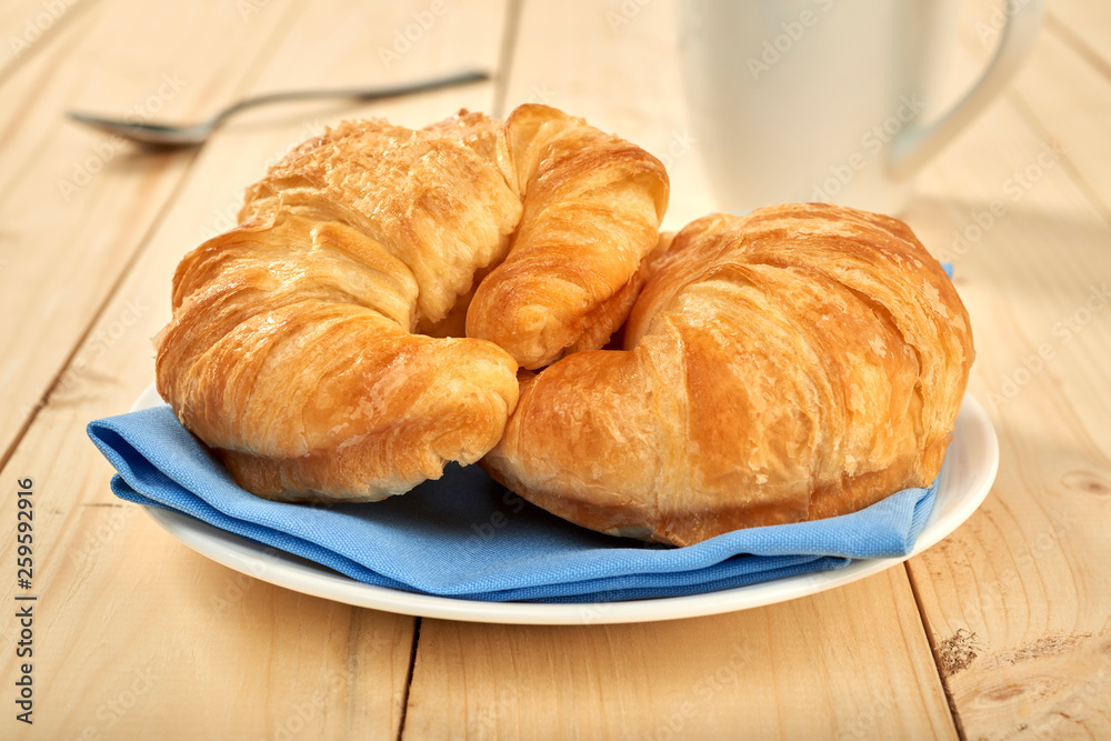fresh baked croissants on wooden table