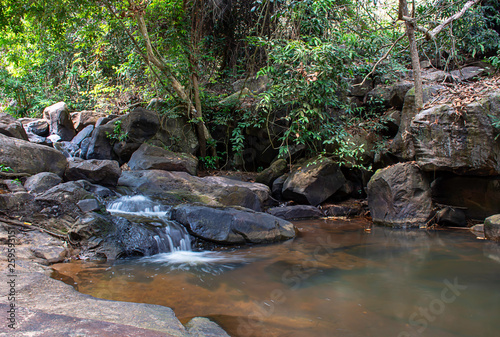 The water flowing over rocks and trees down a waterfall at Khao Ito waterfall , Prachin Buri in Thailand. photo