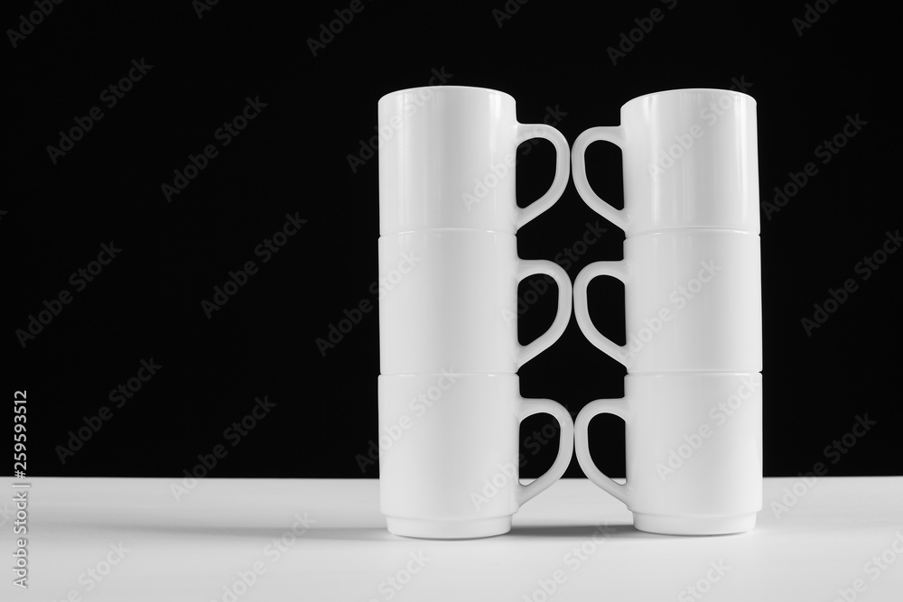 Arrangement of six white mugs with a handle. Black background Arrangement of six white mugs with a handle. Black background