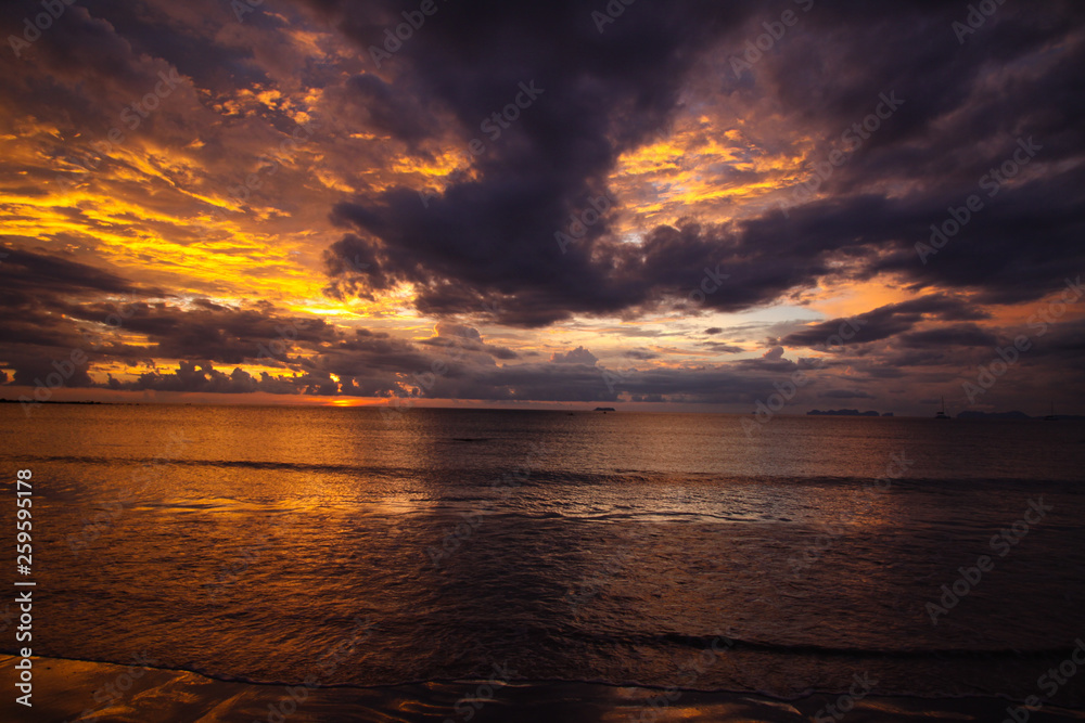 Burning sky and sea during sunset over the ocean of tropical island Ko Lanta, Andaman Sea, Thailand