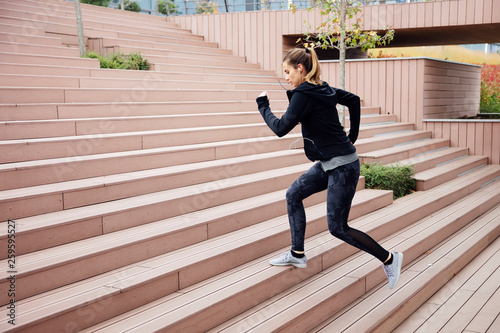 Fit young woman running on steps