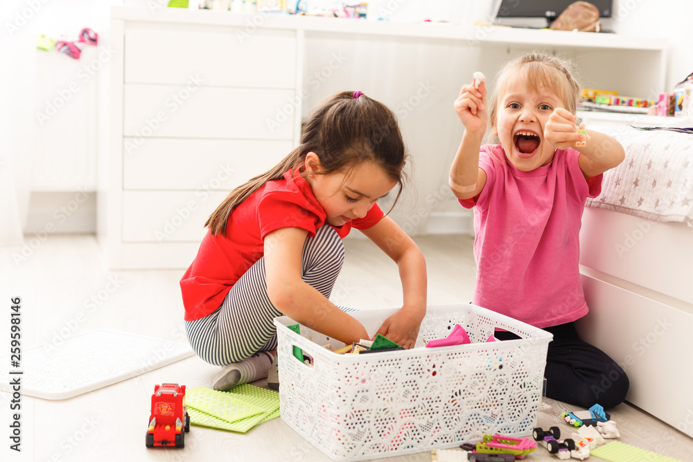 Φωτογραφία Children play with a toy designer on the floor of the children's room