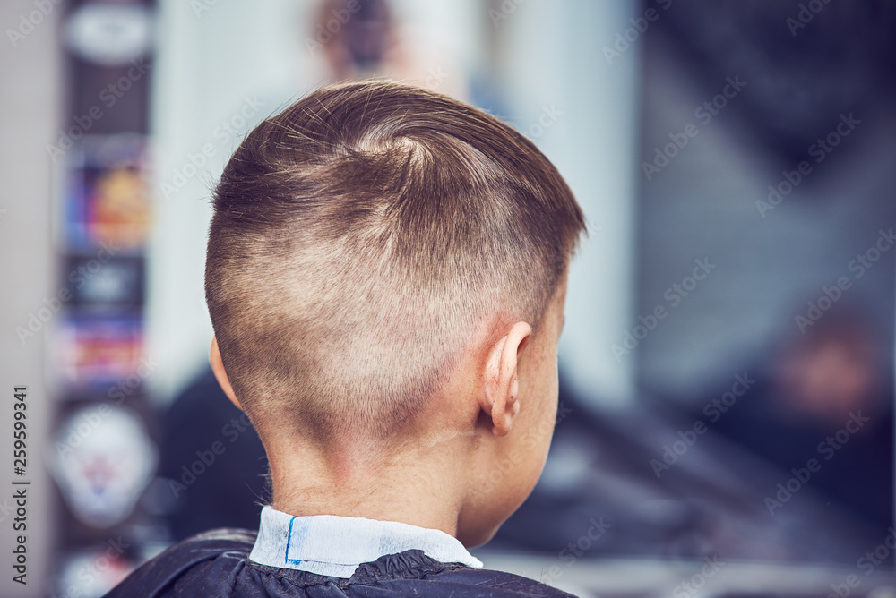 Boy getting hairstyle in barbershop in London. Boy getting hairstyle in barbershop in London.