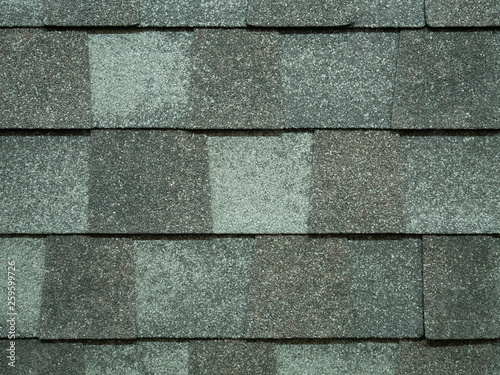 closeup of modern roof trapezoid square shingles tiles in gray color. waterproof scabrous rough surface for house exterior cover