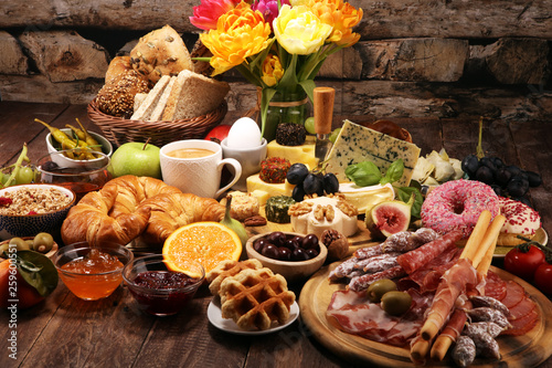 Fotografie breakfast on table with bread buns, croissants, coffe and eggs