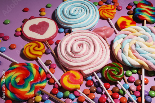 lollipop candies with jelly and sugar. colorful array of different childs sweets and treats on color background