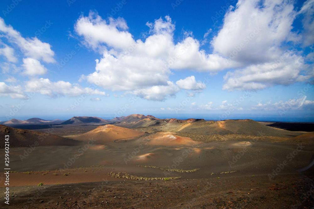 Panoramic view of Lanzarote volcanic island with blue cloudy sky