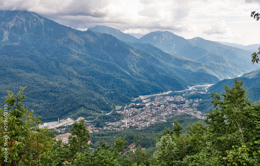 Fototapeta premium Village in a mountain valley among the green forest.