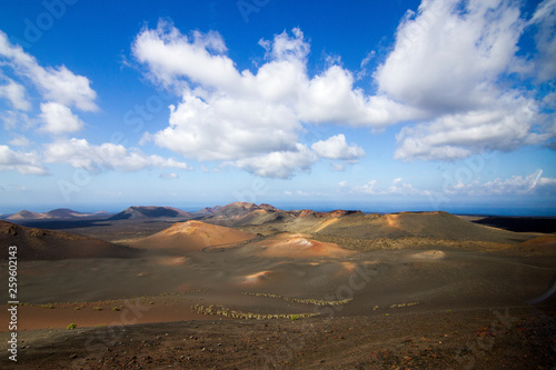 Panoramic view of Lanzarote volcanic island with blue cloudy sky