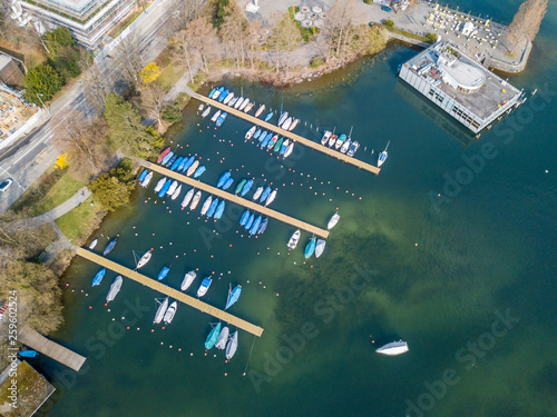 Aerial view of yacht marina on lake in Switzerland. Pier with boats parked near shore on jetty.