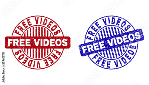 Grunge FREE VIDEOS round stamp seals isolated on a white background. Round seals with grunge texture in red and blue colors. Vector rubber overlay of FREE VIDEOS tag inside circle form with stripes.