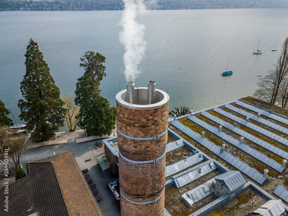 Aerial view of red brick chimney on old brick factory. Smoke coming out chimney. Concept of pollution.