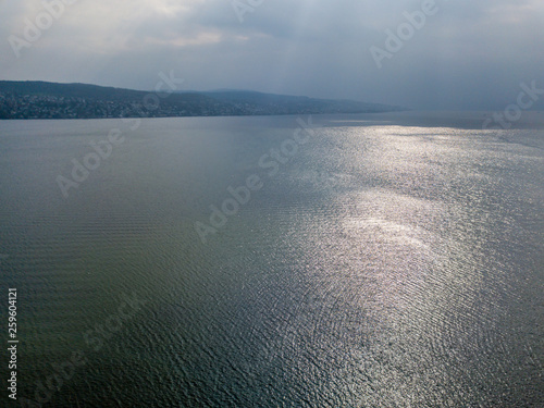 Aerial view of lake with sunlight reflection on water