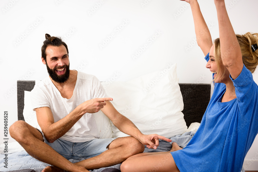 Obraz premium funny couple playing cards on bed