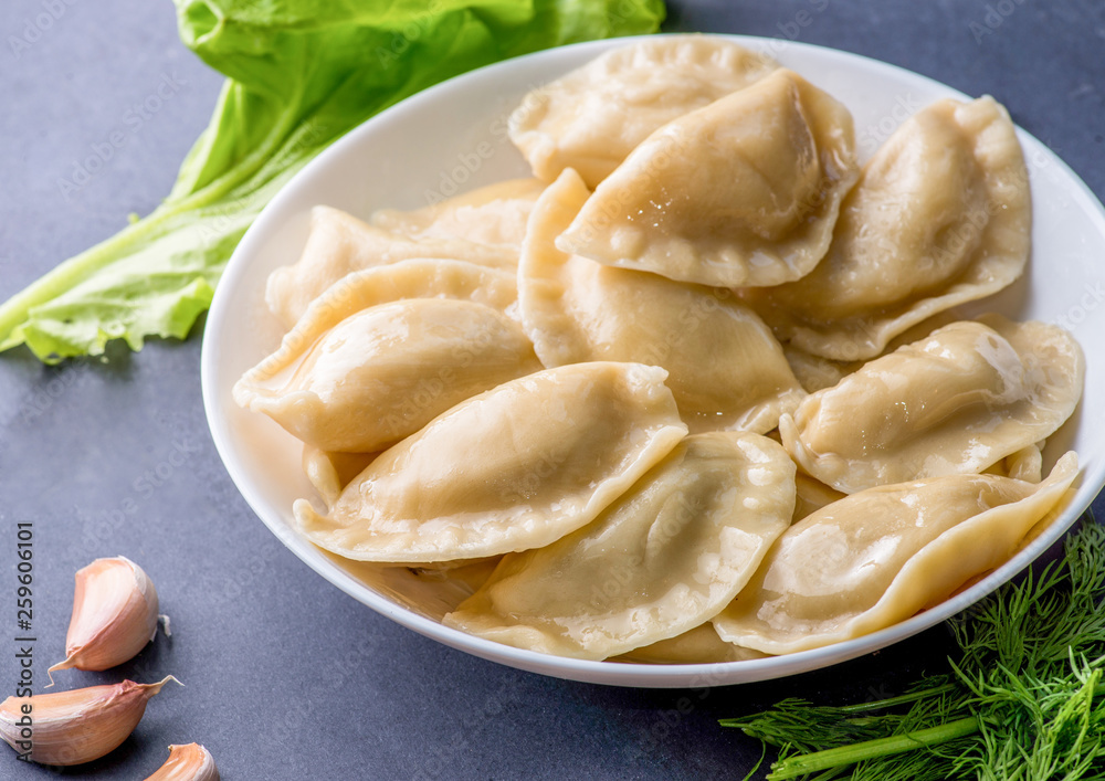 boiled dumplings with filling and sauce on the plate. Steam over a plate boiled dumplings with filling and sauce on the plate. Steam over a plate