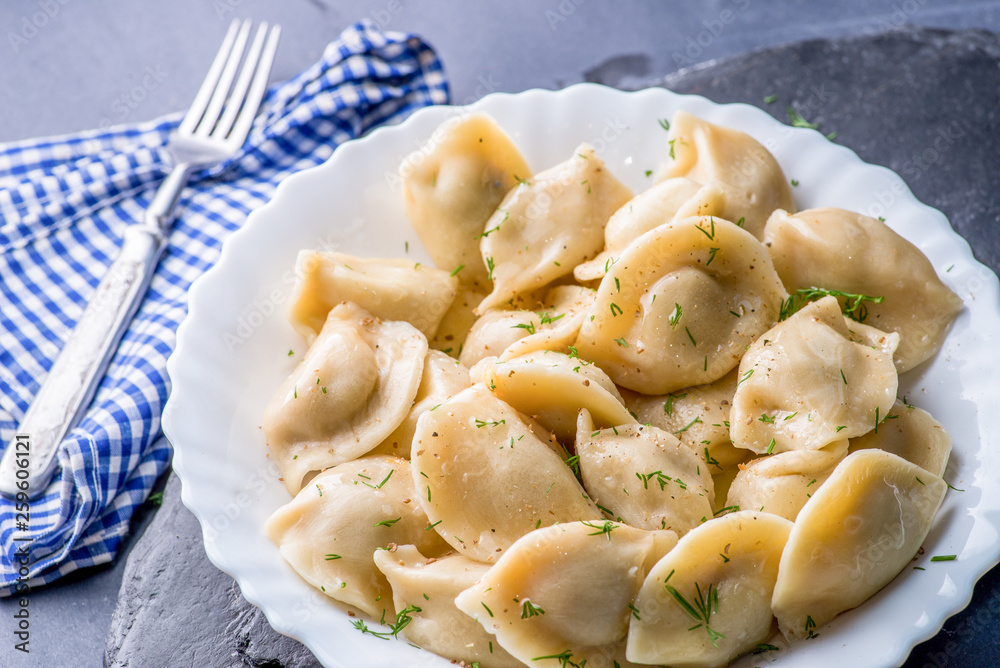 boiled dumplings with filling and sauce on the plate. Steam over a plate boiled dumplings with filling and sauce on the plate. Steam over a plate