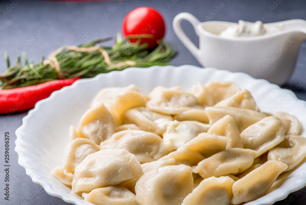 boiled dumplings with filling and sauce on the plate. Steam over a plate boiled dumplings with filling and sauce on the plate. Steam over a plate