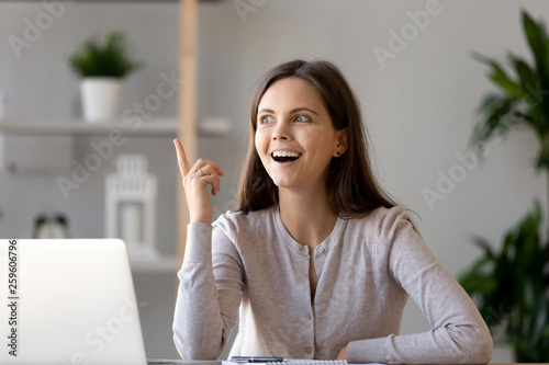 Fotografia Young woman sitting at desk feels excited with good idea