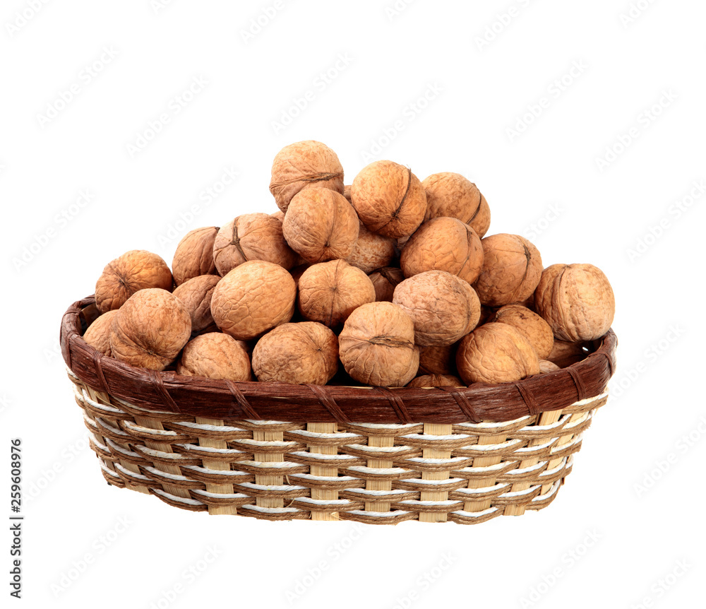Inshell walnuts in a basket on an isolated white background. Inshell walnuts in a basket on an isolated white background.
