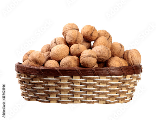 inshell walnuts in a basket on an isolated white background.